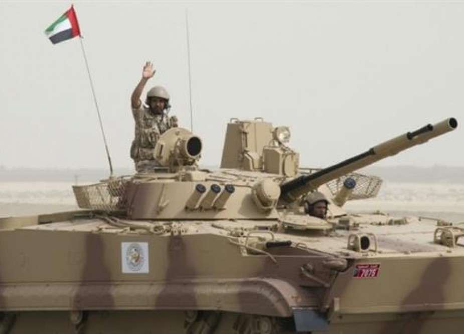 This file photo shows an Emirati soldier waving while riding on a tank in an undisclosed location in Yemen.