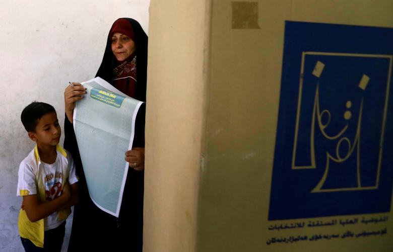 A female security member casts her vote at a polling station two days before polls open to the public in a parliamentary election in Baghdad.