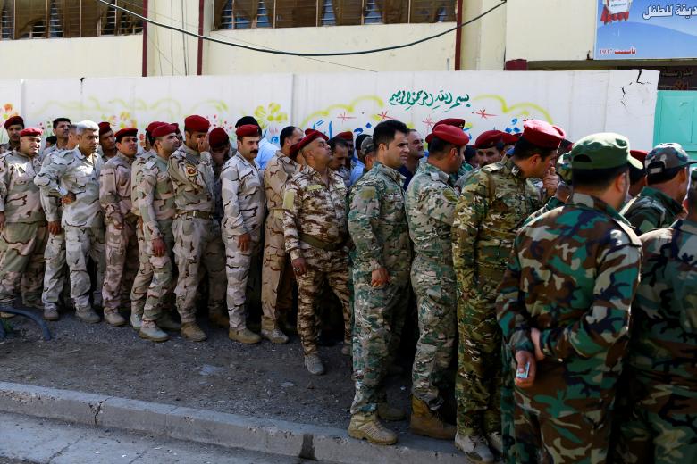 Iraqi security members arrive to cast their vote in Baghdad.
