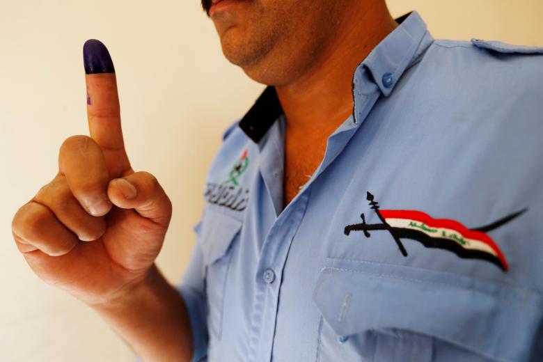 An Iraqi security member shows his ink-stained finger after casting his vote in Baghdad.