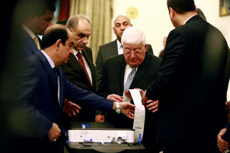 An Iraqi electoral commission official runs President Fouad Masoum and political leaders through a simulation of the voting process, ahead of the parliamentary election, in Baghdad.