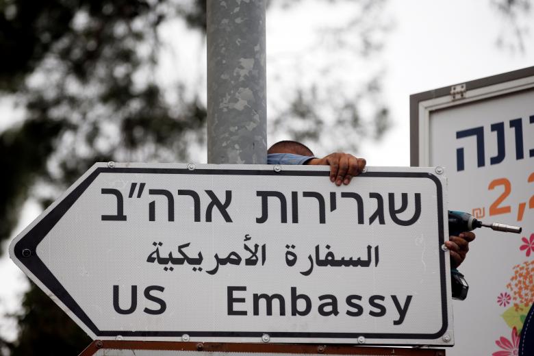 A worker hangs a road sign directing to the U.S. embassy in Jerusalem, May 7.