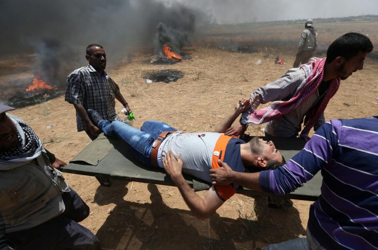 A wounded Palestinian is evacuated during a protest against U.S. embassy move to Jerusalem and ahead of the 70th anniversary of Nakba, at the Israel-Gaza border in the southern Gaza Strip.