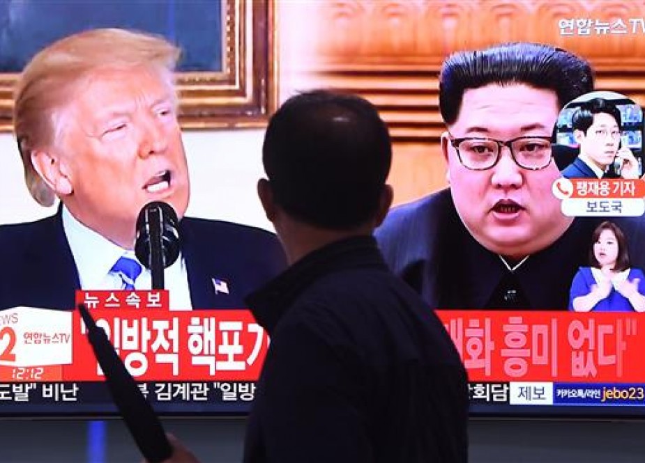 A man walks past a television news screen showing North Korean leader Kim Jong-un (R) and US President Donald Trump (L) at a railway station in Seoul on May 16, 2018. (Photos by AFP)