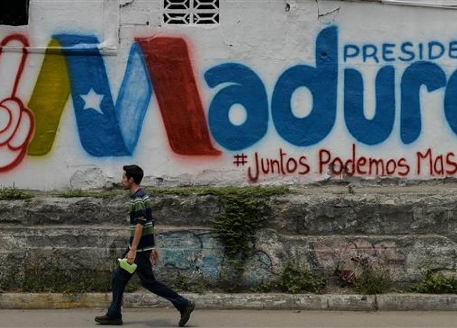 A man walks past graffiti in support of Venezuelan President Nicolas Maduro, in Barquisimeto, Venezuela, on May 19, 2018, on the eve of the country’s presidential election. (Photo by AFP)