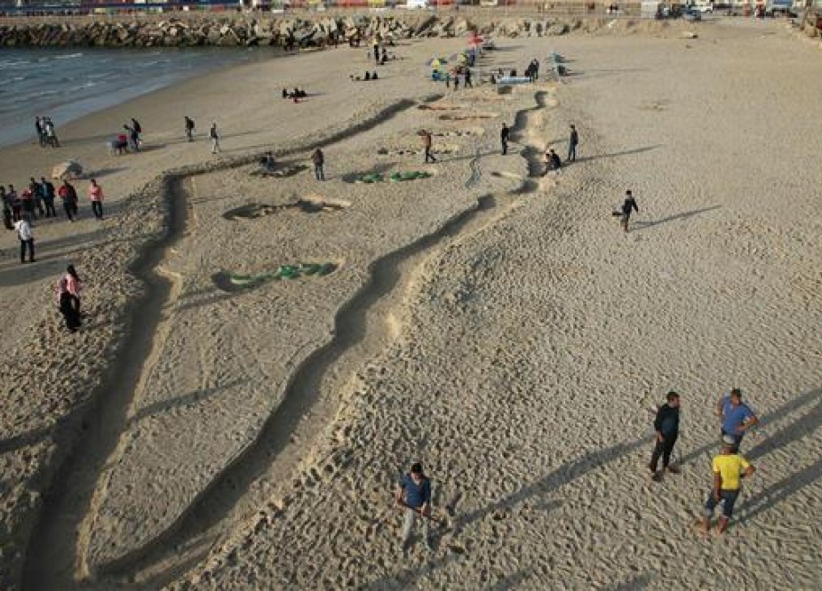 Palestinian artist Osama Spita depicting a map in the sand at a beach in Gaza City.jpg