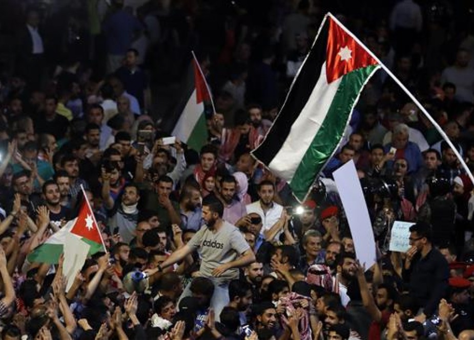 Jordanian demonstrators wave the national flags during a protest near the prime minister