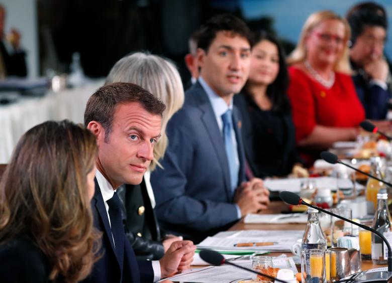Canadian Prime Minister Justin Trudeau speaks as French President Emmanuel Macron looks on at a G7 and Gender Equality Advisory Council meeting.