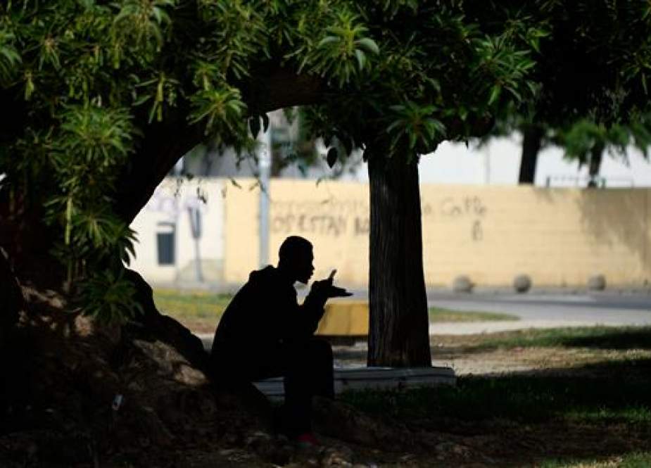 A refugee speaks on his phone outside a gymnasium used as a reception center in Jerez de la Frontera, southern Spain, June 21, 2018. (File photo by AFP)