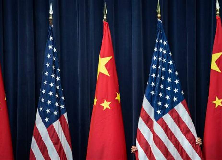 In this file photo, taken on July 10, 2013, a staff member adjusts a US flag before the opening session of the US and China Strategic and Economic Dialog at the US Department of State in Washington, DC. (By AFP)