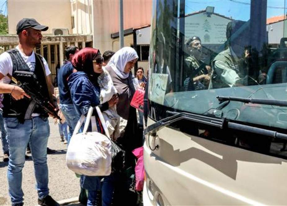Syrian refugees board a bus evacuating them from Masnaa Lebanon, Lebanon-Syria border.jpg