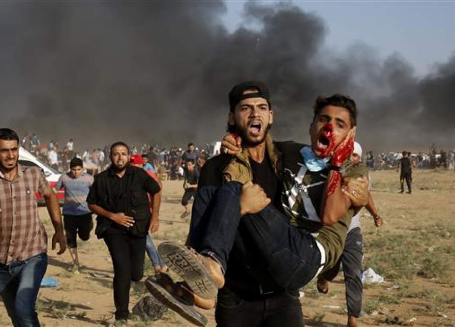 Injured Palestinian is being carried away from the scene of clashes with Israeli forces east of Gaza City.jpg