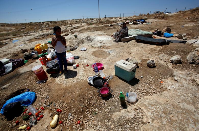 A Palestinian girl stands next to belongings after the Israeli army removed her family's tent at Susiya village, south of Hebron in the occupied West Bank.