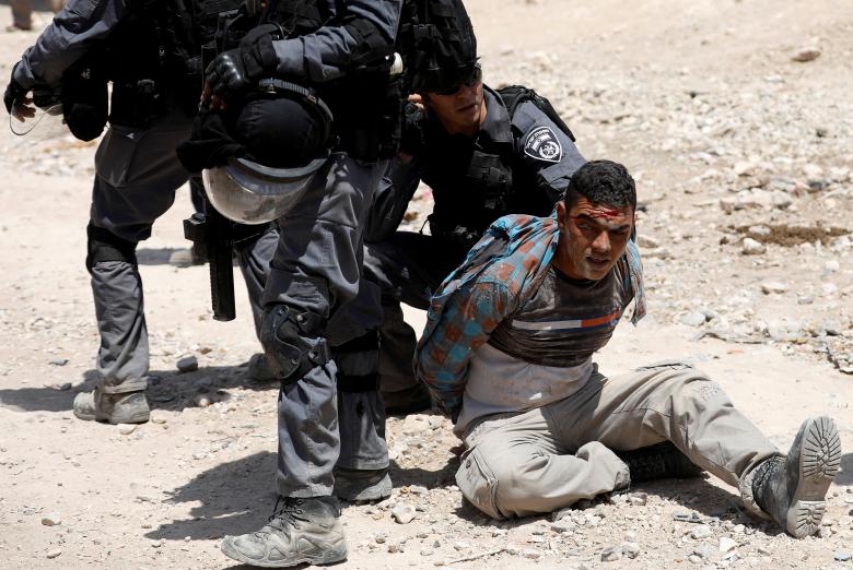Israeli policemen detain a Palestinian in the Bedouin village of al-Khan al-Ahmar near Jericho in the occupied West Bank.