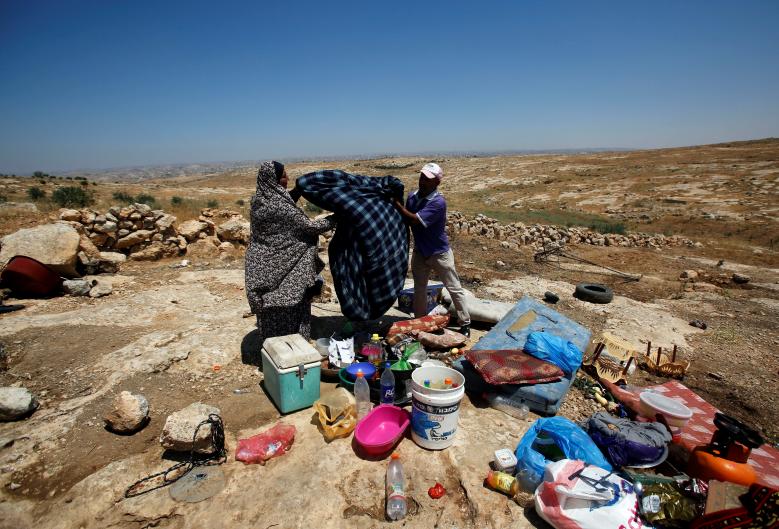 Palestinians check their belongings after the Israeli army removed their tent at Susiya village, south of Hebron in the occupied West Bank.