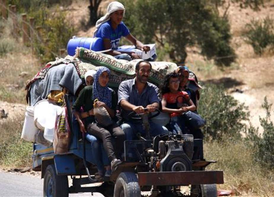 Syrians ride a vehicle carrying their personal belongings as they return to their homes in towns and villages situated on the southwestern province of Dara