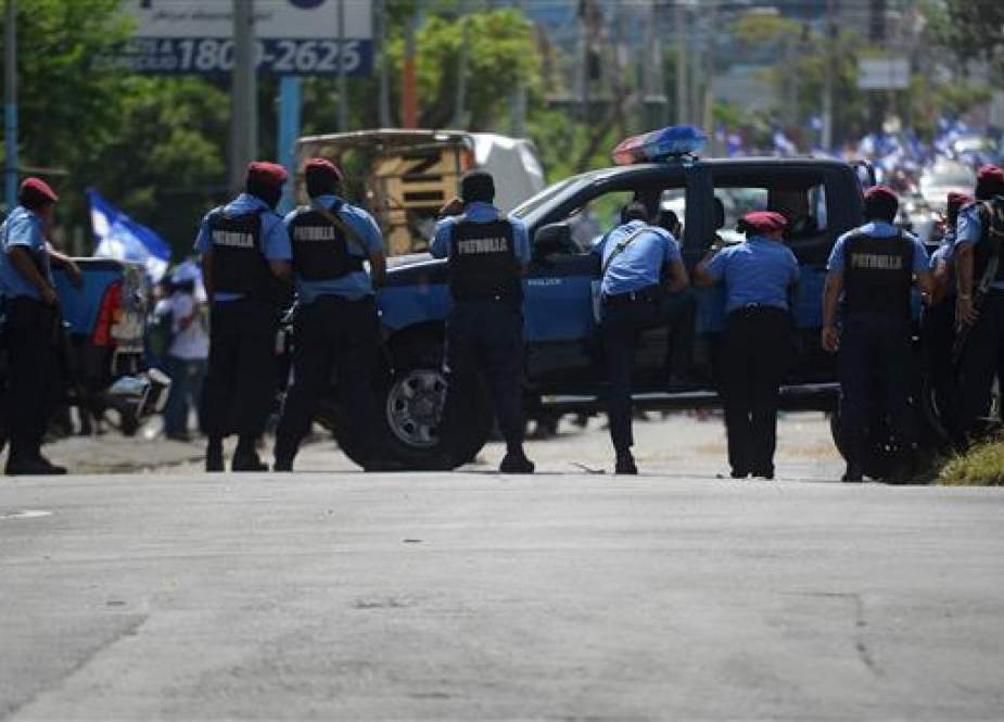 Police stand guard in the surroundings of the Cathedral as students of the National Autonomous University of Nicaragua (UNAN) arrive in Managua, on June 14, 2018. (Photo by AFP)