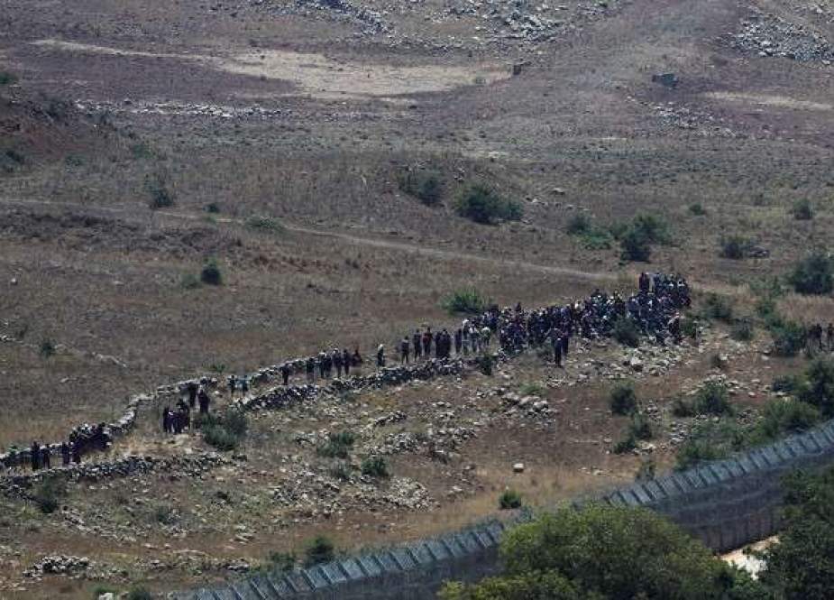 العشرات من السوريين يتجمعون قرب السياج الإسرائيلي