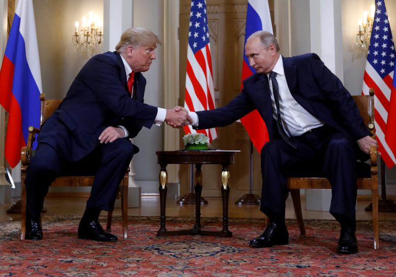 U.S. President Donald Trump and Russia's President Vladimir Putin shake hands as they meet.