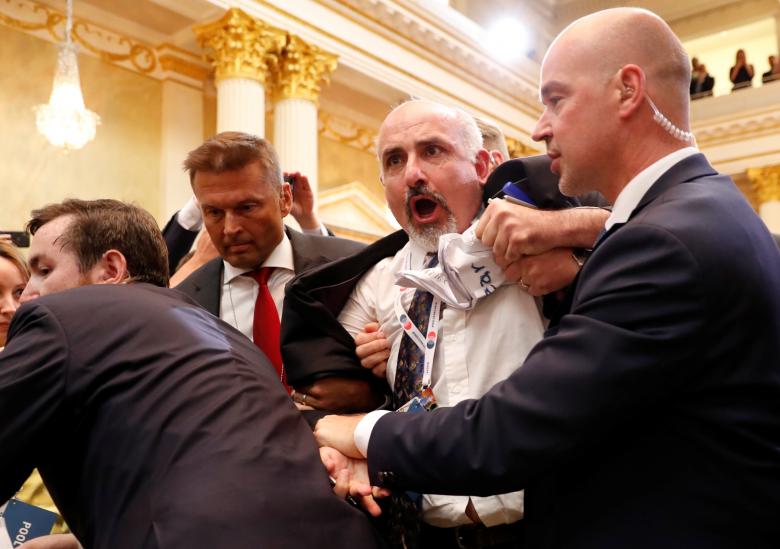 Security personnel removes a man from the premises before Trump and Putin's joint news conference.