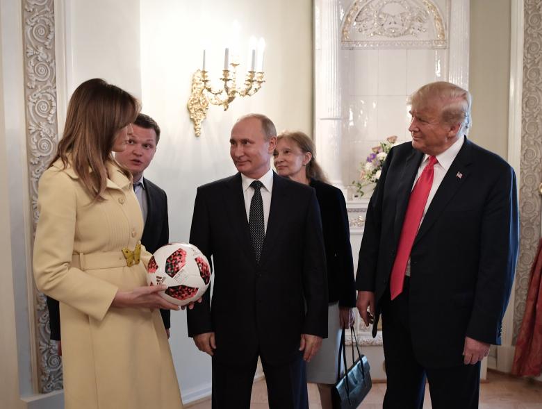 Russia's President Putin (C), U.S. President Donald Trump (R) and first lady Melania Trump speak during a meeting.