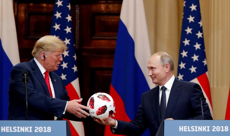U.S. President Trump receives a football from Russian President Putin as they hold a joint news conference.