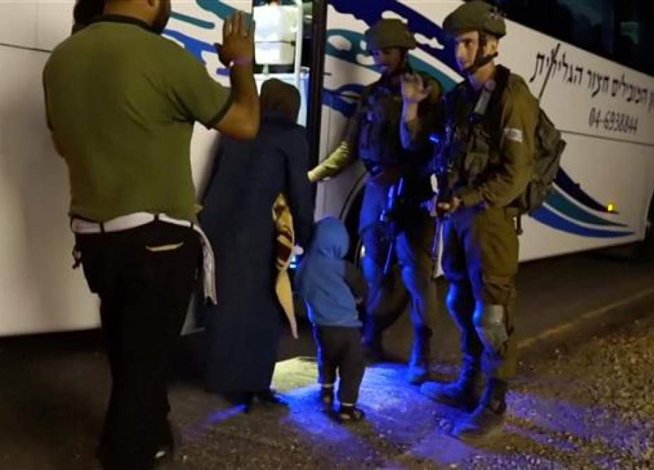 People walk past Israeli soldiers as they board a bus during extraction of the so-called “White Helmets” members from the occupied Golan Heights to Israel in this still image taken from video provided by the Israeli Army July 22, 2018. (Photo via Reuters)