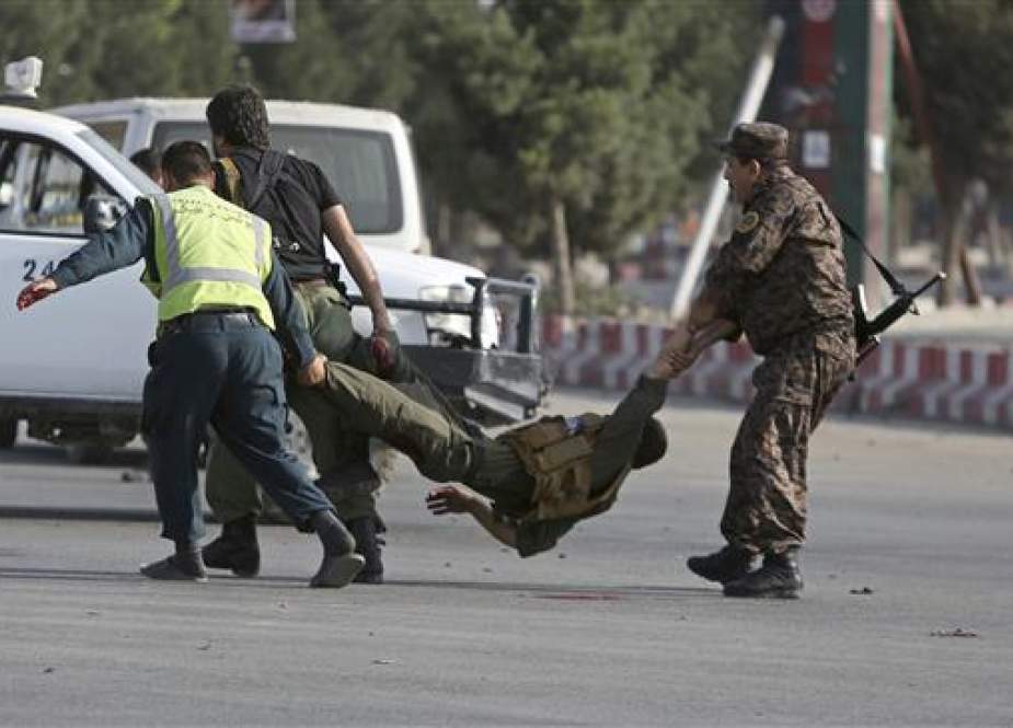 Afghan security personnel carry an injured officer after an attack near the Kabul International Airport in Afghanistan on July 22, 2018. (Photo by AP)