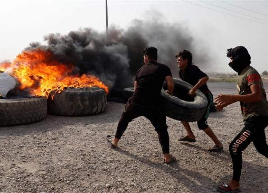 Three people are burning tires in protest against unemployment and lack of basic services in the southern Iraqi city of Basra on July 17, 2018. (AFP)