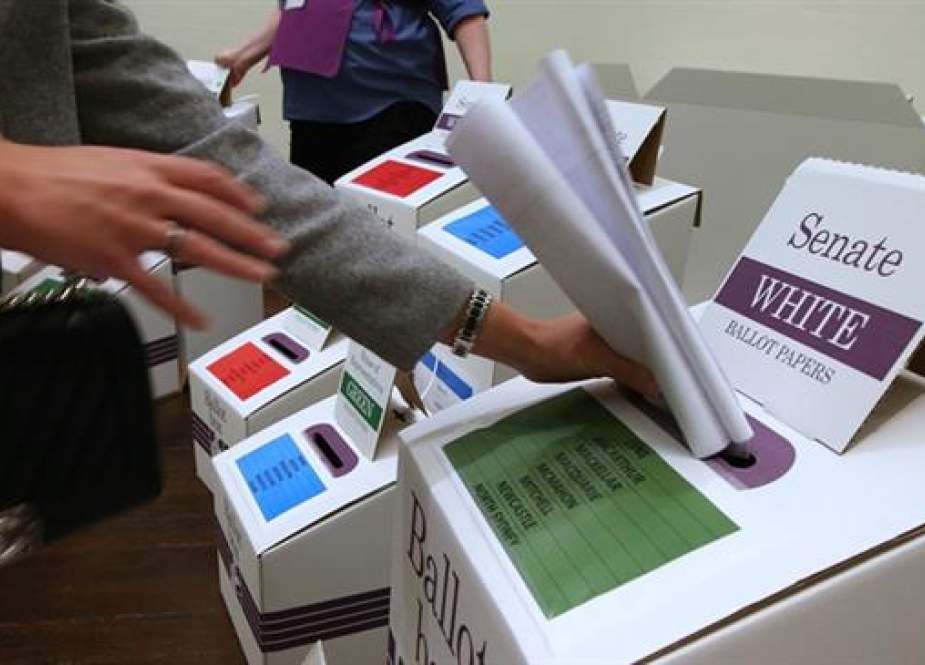 A voter places ballot in a box at a polling station at Town Hall in Sydney. ( File Photo by AP)