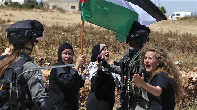 Palestinian activist Ahed Tamimi, right, reacts in front of Israeli forces during a demonstration on May 26, 2017, in the village of Nabi Saleh, north of Ramallah, the occupied West Bank.