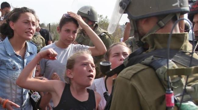 This photo, taken on November 2, 2012, shows young Ahed Tamimi, center, gesturing in front of an Israeli soldier during a protest against the confiscation of Palestinian land by Israel in the West Bank village of Nabi Saleh near Ramallah.