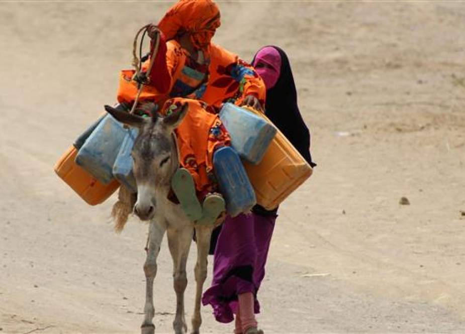 Yemeni children displaced from the Red Sea port city of Hudaydah walk with a donkey to fill up their jerry-cans with water, at a camp for the displaced in nearby Khokha on June 22, 2018.(Photo by AFP)