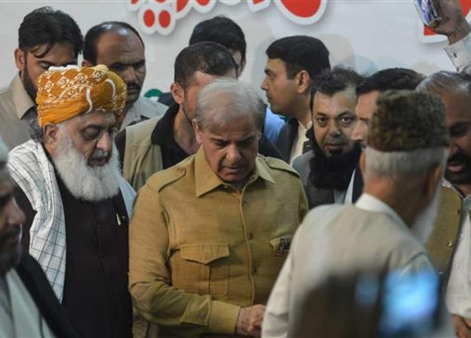 Shahbaz Sharif (C), the younger brother of ousted Prime Minister Nawaz Sharif and head of the Pakistan Muslim League-Nawaz (PML-N), arrives with opposition leader Maulana Fazalur Rehman (2nd L) for a press conference in Islamabad on July 27, 2018. (Photo by AFP)