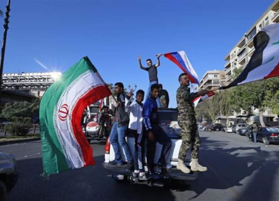 Syrians flash victory signs and wave Syrian, Iranian and Russian flags in Damascus, Syria, April 14, 2018. (Photo by AP)