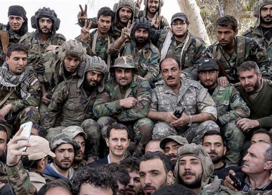 A file photo of Syrian President Bashar al-Assad (C) among a group of army soldiers