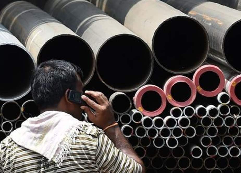 Indian truck loads steel pipes at an industrial area in Mumbai..jpg