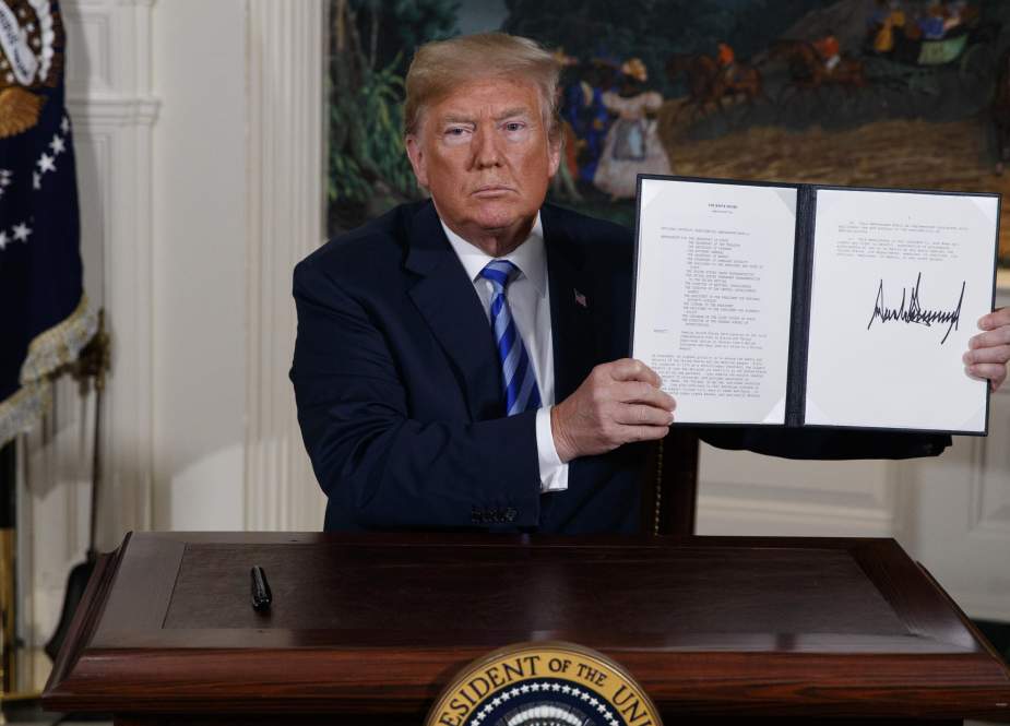 President Donald Trump shows a signed Presidential Memorandum after delivering a statement on the Iran nuclear deal from the Diplomatic Reception Room of the White House, May 8, 2018, in Washington.
