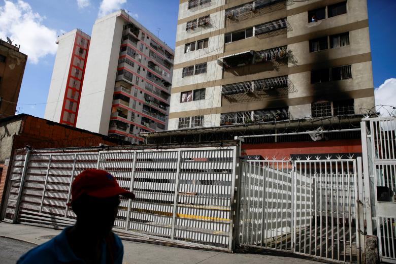 A man walks past a building where damages are seen after an explosion in Caracas, August 5, 2018. Six people have been detained, authorities said on Sunday. Intelligence agents on Monday searched an upscale hotel in eastern Caracas, workers at the hotel 