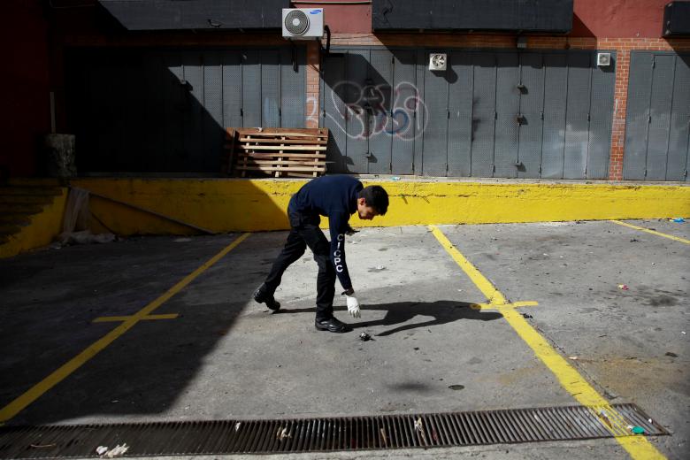 A criminal investigator looks for evidence in a building after an explosion in Caracas, August 5, 2018. The president later described the attack, which injured seven soldiers, as an assassination attempt. The government's adversaries warned of a possible