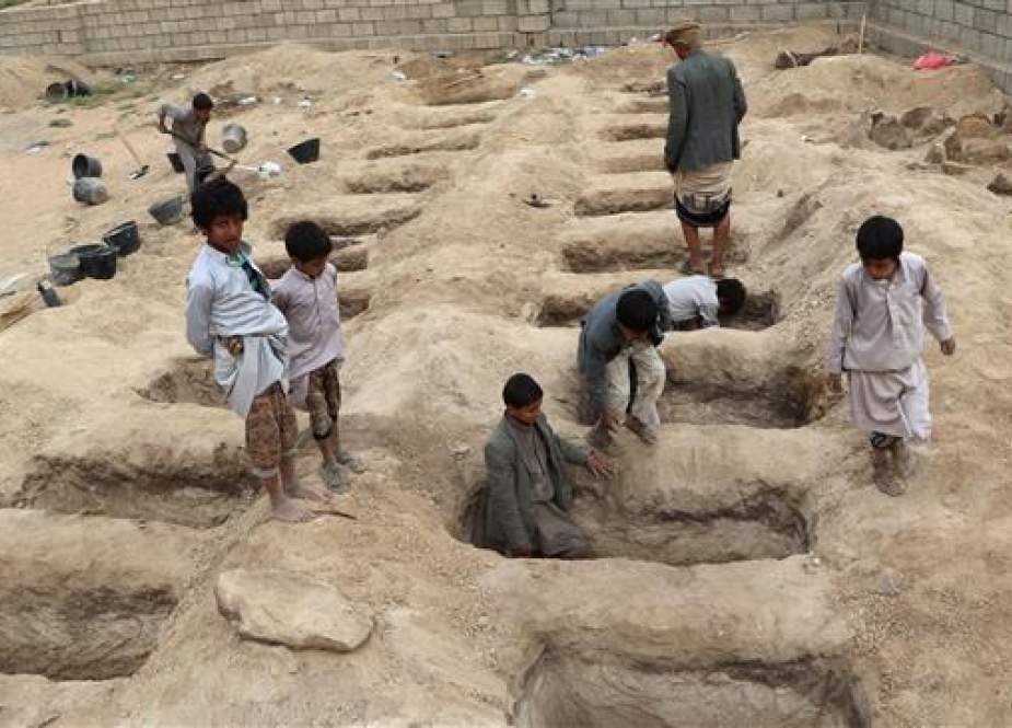 Boys inspect graves prepared for victims of Thursday