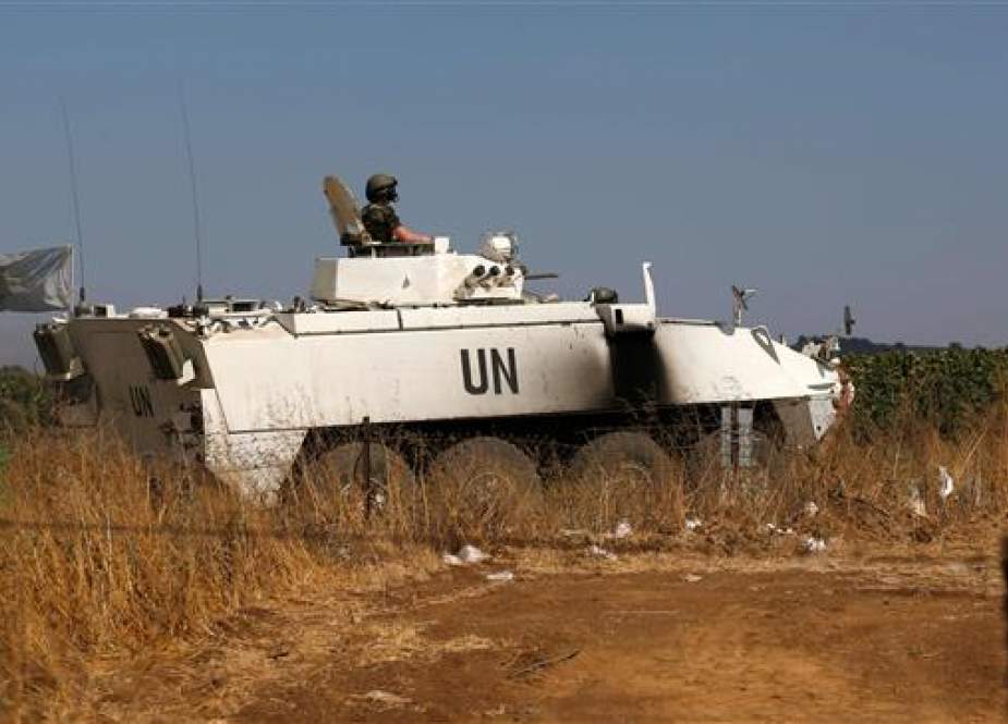 A peacekeeper from the UN Disengagement Observer Force (UNDOF) stationed in the Israeli-occupied Golan Heights sits in an infantry fighting vehicle while on patrol near the Quneitra crossing checkpoint on July 20, 2018. (Photo by AFP)