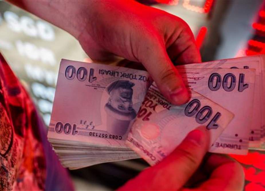 A money changer counts Turkish lira banknotes at a currency exchange office in Istanbul, August 8, 2018. (AFP)