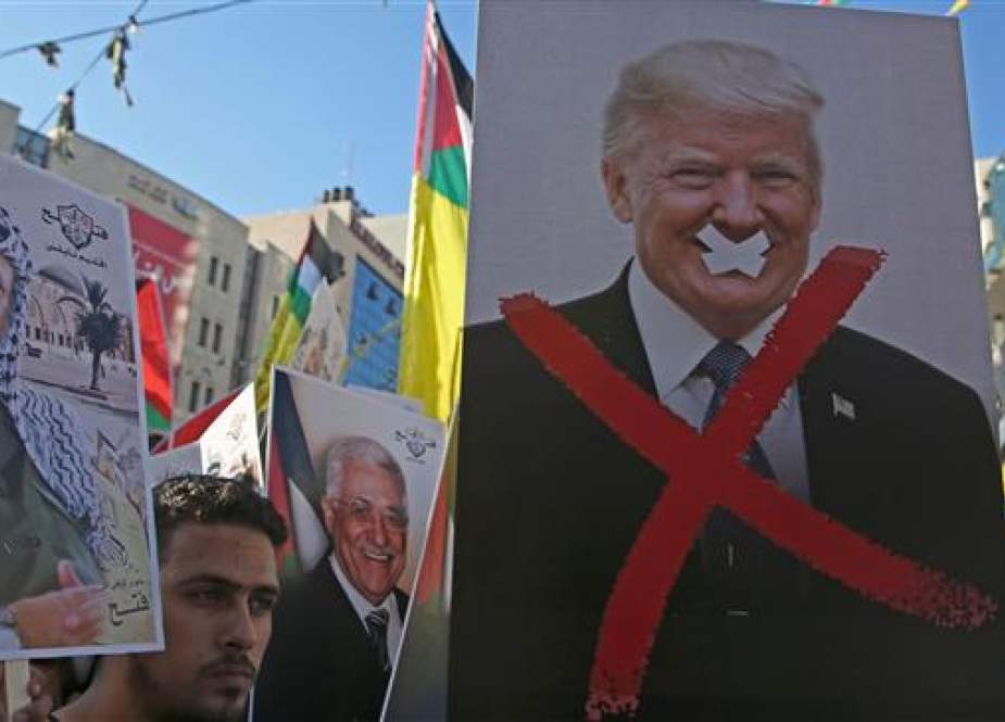 In this file photo taken on July 17, 2018 Palestinian protestors hold portraits of late Palestinian leader Yasser Arafat and US President Donald Trump during a rally in support to the Fatah movement in the West Bank city of Nablus. The United States said Friday August 24, 2018 that it had canceled more than $200 million in aid for the Palestinians in the Gaza Strip and West Bank. (AFP photo)