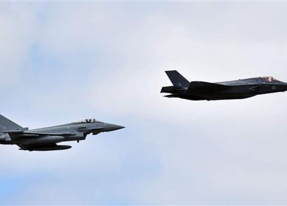 A British Royal Air Force (RAF) Lockheed Martin F-35 Lightning II (R) and a Eurofighter Typhoon aircraft perform a fly-past during the Farnborough Airshow, south west of London, on July 17, 2018. (Photo by AFP)
