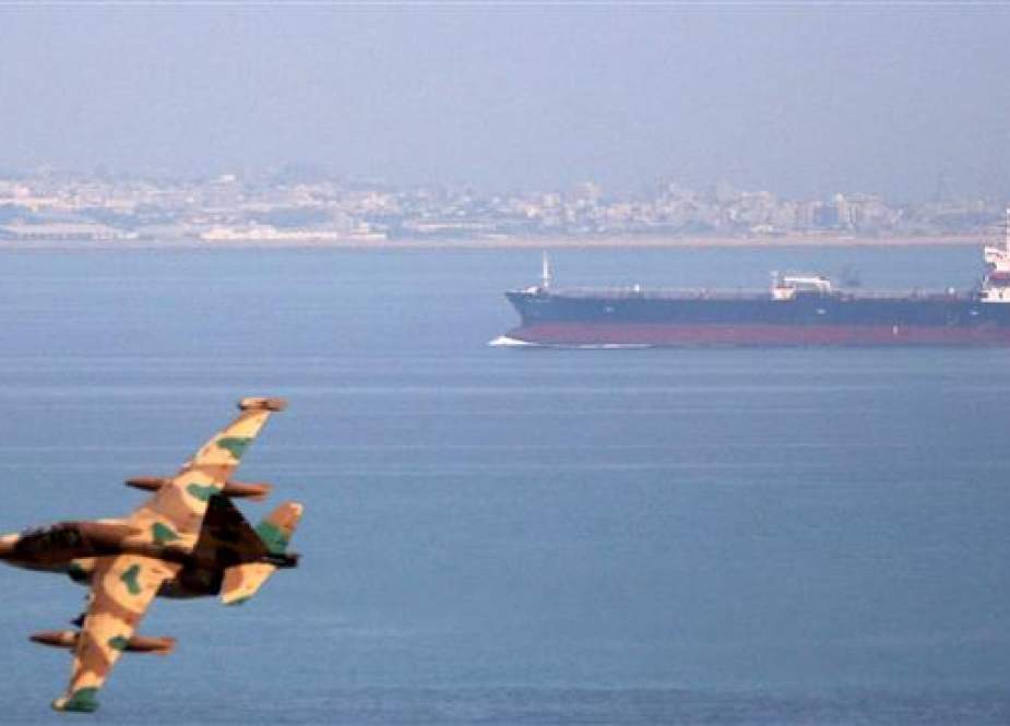 An Iranian military fighter plane flies past an oil tanker during naval maneuvers in the Sea of Oman on April 5, 2006. (Photo by Reuters)
