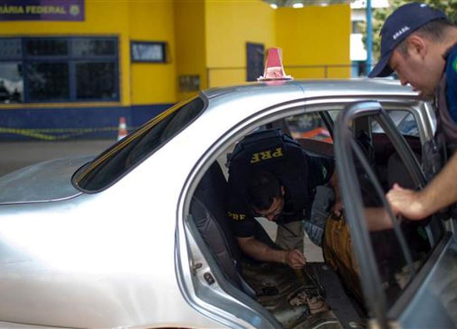 Brazilian Federal Road Police officers check a Venezuelan taxi on its way to Brazil at the Brazilian Migration Office in the border city of Pacaraima, Roraima State, Brazil, August 20, 2018. (Photo by AFP)