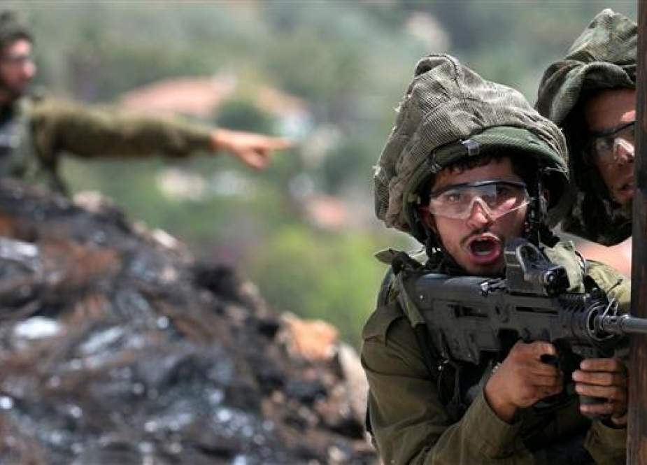 Israeli soldier aims his weapon during clashes with Palestinian protesters