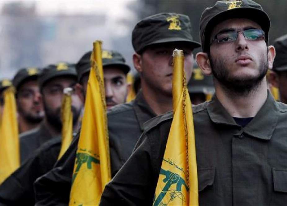 The file photo shows Hezbollah fighters holding flags of the Lebanese resistance movement during a parade in a southern suburb of Beirut, Lebanon. (AP photo)