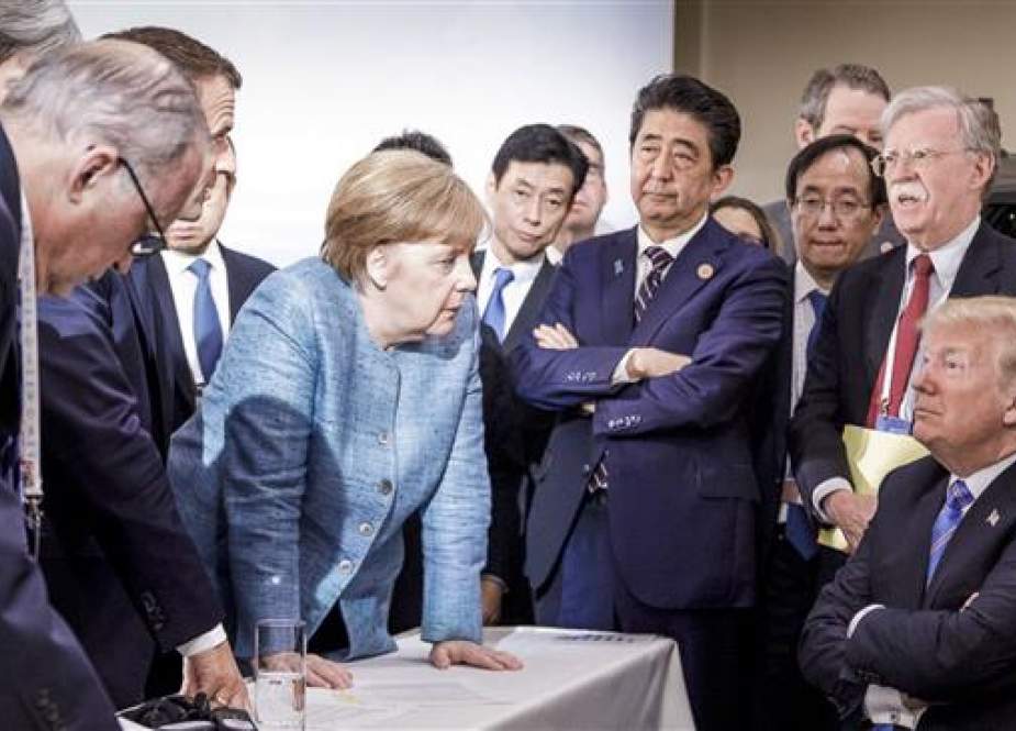 In this photo made available by the German Federal Government, German Chancellor Angela Merkel speaks with President Trump during the G7 Leaders Summit in La Malbaie, Quebec, Canada, in June 2018